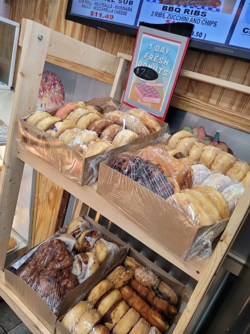 Counter menu showing donuts and sandwiches.